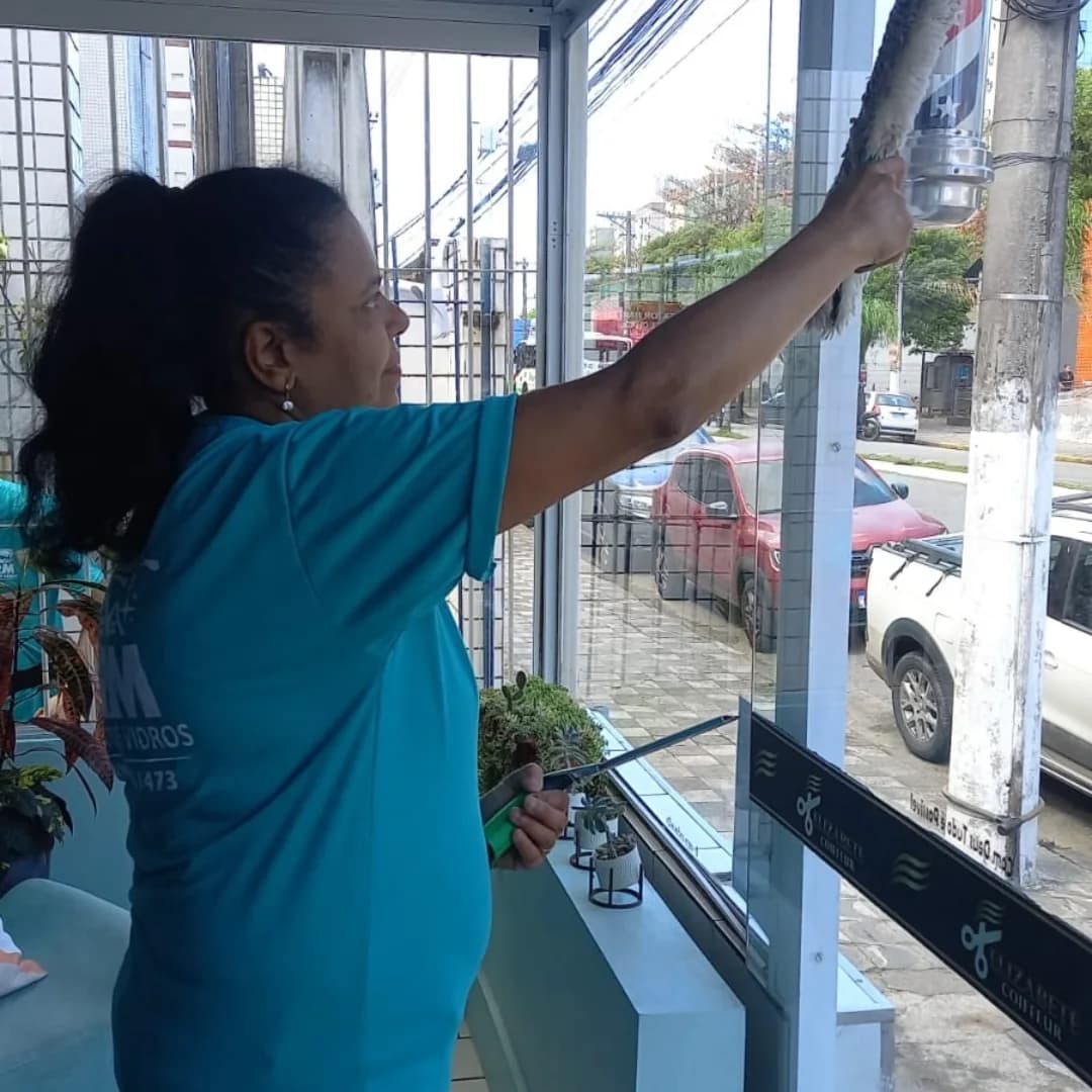 Profissional uniformizada da ARM limpando uma janela